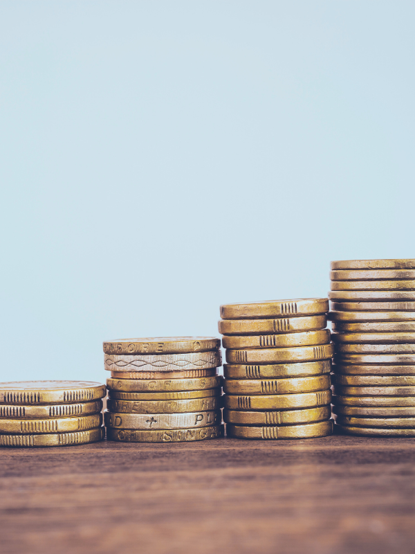 Business Funding - coins stacked against a blue background